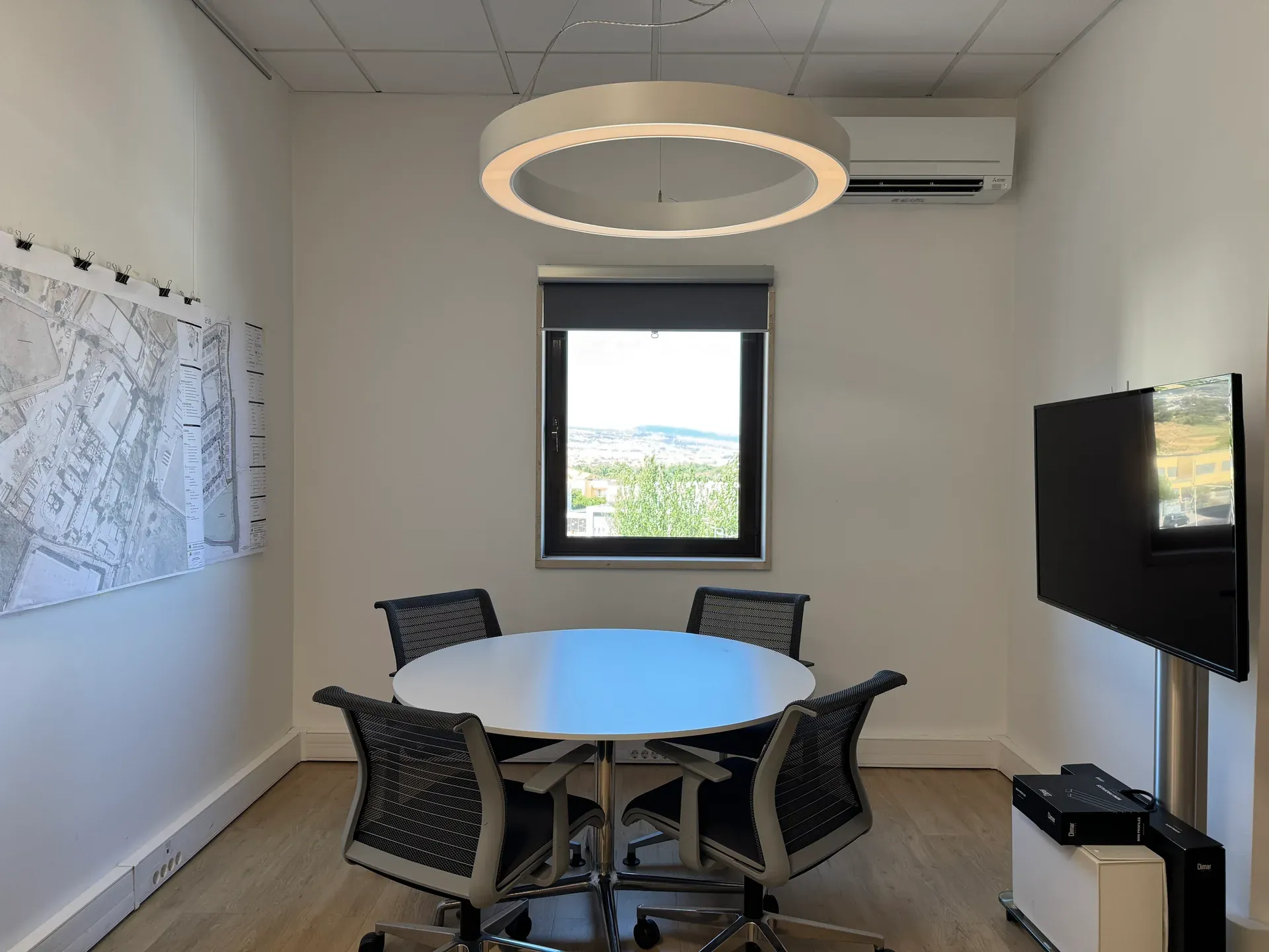 Sala de reuniões do atelier, com uma planta de ordenamento afixada na parede