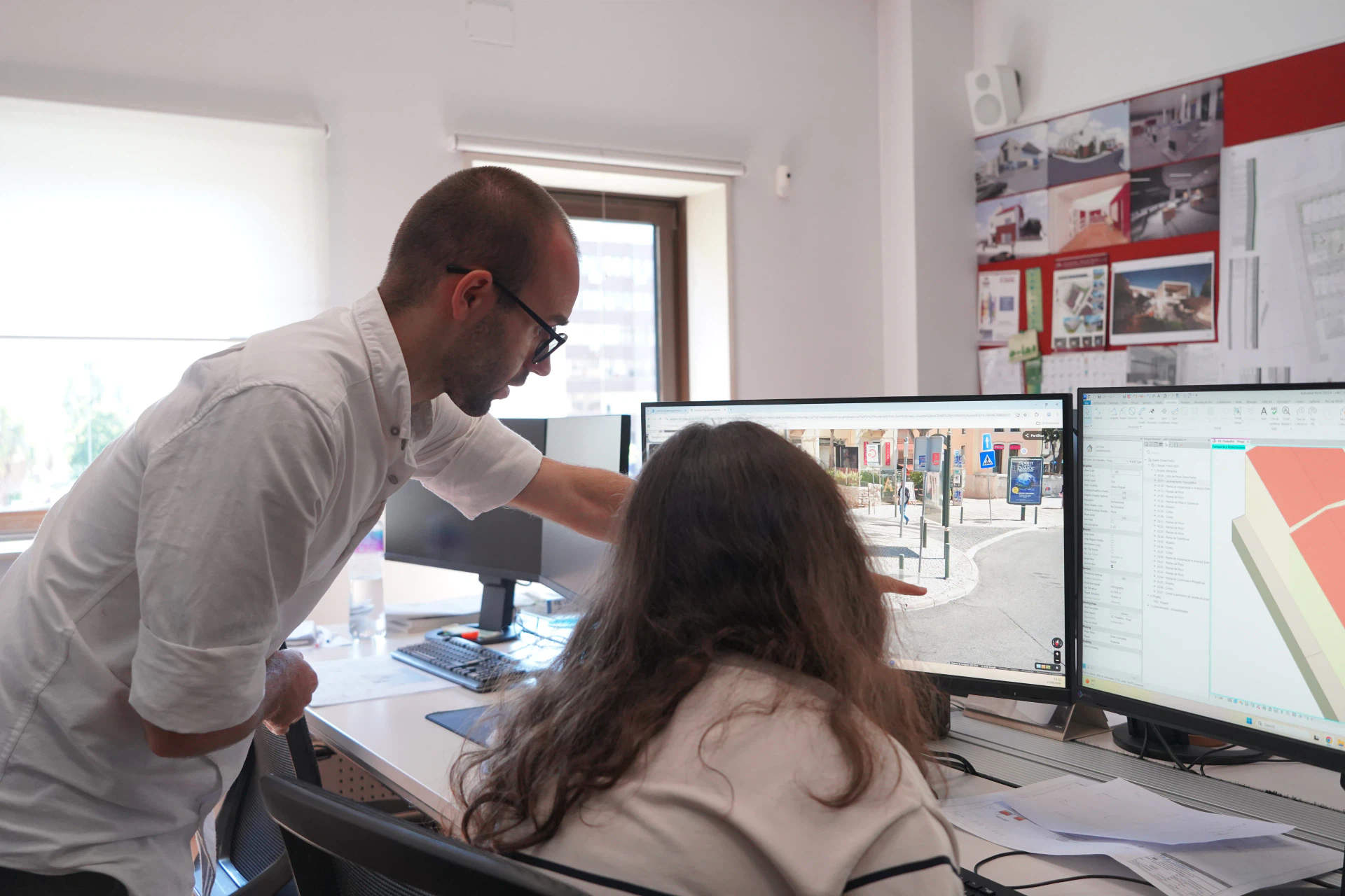 Dois arquitetos do atelier a rever um projeto num posto de trabalho, com o levantamento fotográfico da rua num ecrã e o modelo em ecrã ao lado